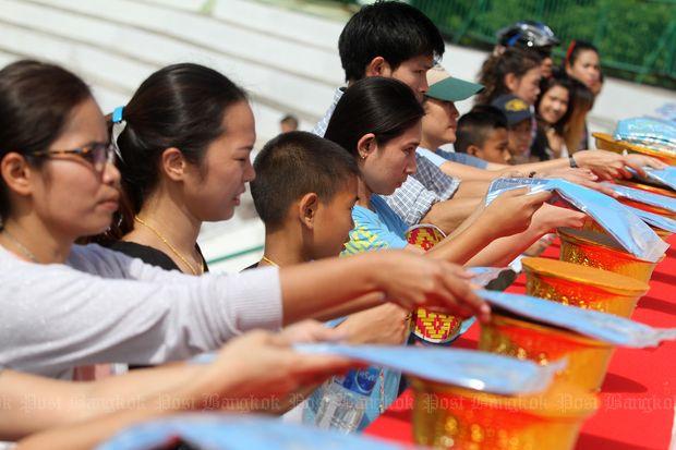 A group of participants receive the T-shirt before the image of Her Majesty the Queen and His Royal Highness Crown Prince Maha Vajiralongkorn. (Photos by Thanarak Khunton)