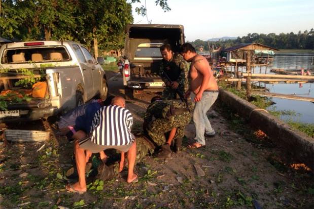 Rescue bid: Locals help a wounded soldier after a bombing in Pattani Buri yesterday.